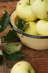 Delicious green apples with leaves on the table