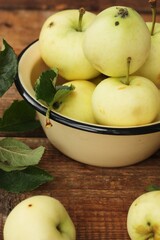 Delicious green apples with leaves on the table