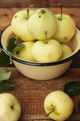 Delicious green apples with leaves on the table
