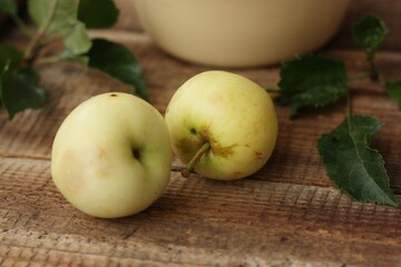 Delicious green apples with leaves on the table