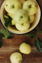Delicious green apples with leaves on the table