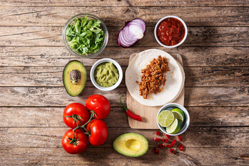 Mexican tacos ingredients on wooden table
