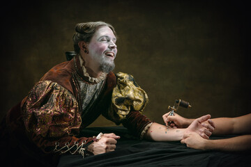 Making tattoo. Young man as Johann Bach isolated on dark green background. Retro style, comparison...