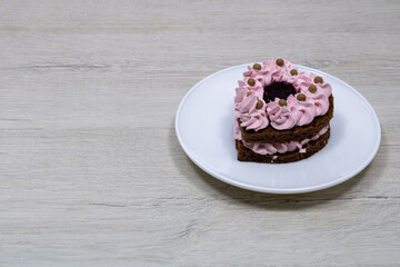 Cake in a white saucer. Cake in a saucer on a bleached wood table.