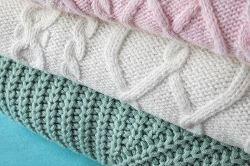 Fototapeta na wymiar Stack of folded warm sweaters, closeup view