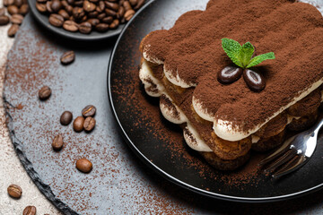 Classic tiramisu dessert on ceramic plate on concrete background