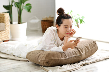 スマートフォンを持つ笑顔の若い女性