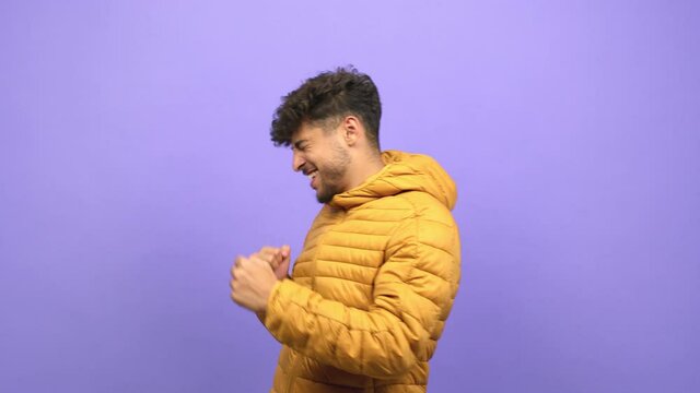 Young arab man dancing and having fun, moving arms listening to music
