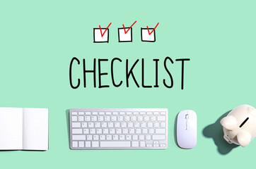 Checklist with a computer keyboard and a piggy bank