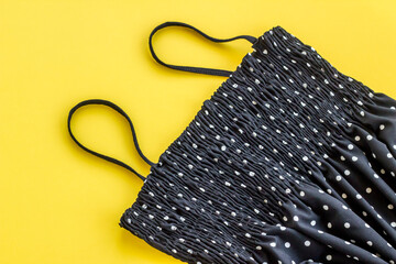 Black strappy summer dress with white dots on yellow background