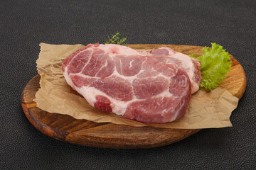 Raw pork steak over wooden board
