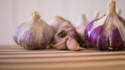 Beautiful, fresh and young garlic is plucked from the garden and lies on a wooden plank.