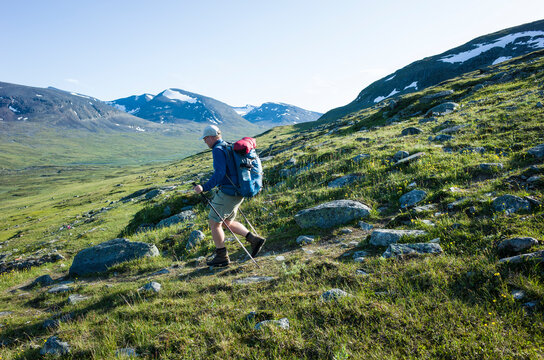 Hiking in Swedish Lapland. Man traveler trekking alone Nordkalottruta Arctic Trail in northern Sweden. Mountain nature of Scandinavia in summer sunny day
