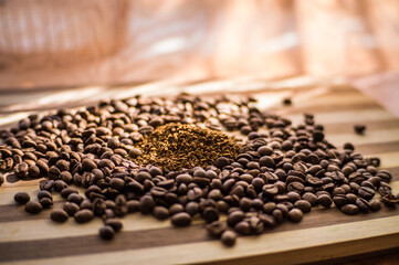 Naklejka premium Roasted coffee beans are scattered on a wooden board and instant coffee is scattered inside.