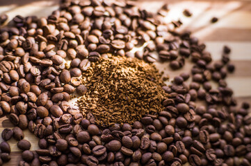 Roasted coffee beans are scattered on a wooden board and instant coffee is scattered inside.