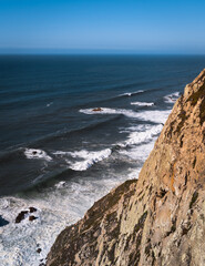 Rocky ocean shore, white waves against the rocks, view from above