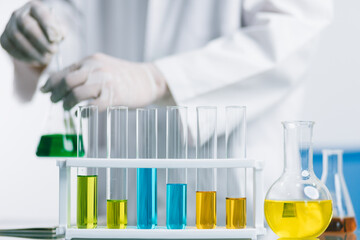 Biochemical research scientist working with science laboratory test tubes for coronavirus vaccine development in pharmaceutical research labolatory