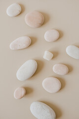 Fototapeta na wymiar Pale pastel stones on neutral stones. Flat lay, top view spa concept.
