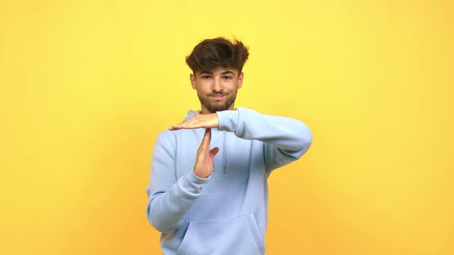 Young arab man tired and bored, doing a timeout gesture, needs to stop because of work stress, time concept