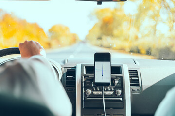 phone with navigation at car dashboard autumn speedway