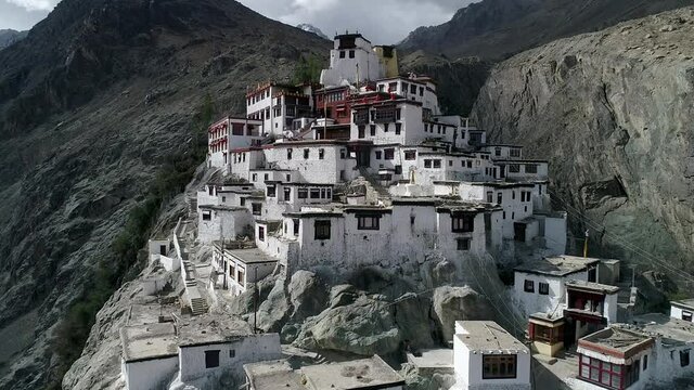 aerial view of an ancient remains of buddhist monastery on a rocky mountain.camera moving vertically downward. descriptive shot.