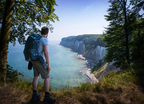 person with a backpack gazing at the chalk cliffs of r&uuml;gen