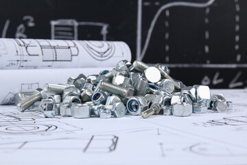 Bolts and nuts on background of engineering drawings. Science, mechanics and mechanical engineering