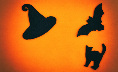 Happy Halloween holiday concept. Bat, cat, hat on an orange background. Layout of a Halloween greeting card with a copy of the space. Flat bed, top view