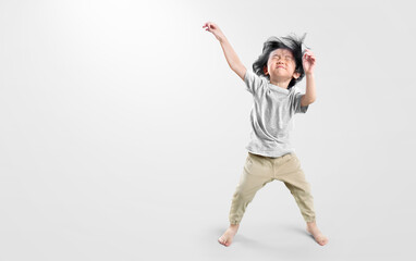 Obraz premium Happy asian boy actively, exicte and dancing against isolated on clean bright background. Education concept for school.