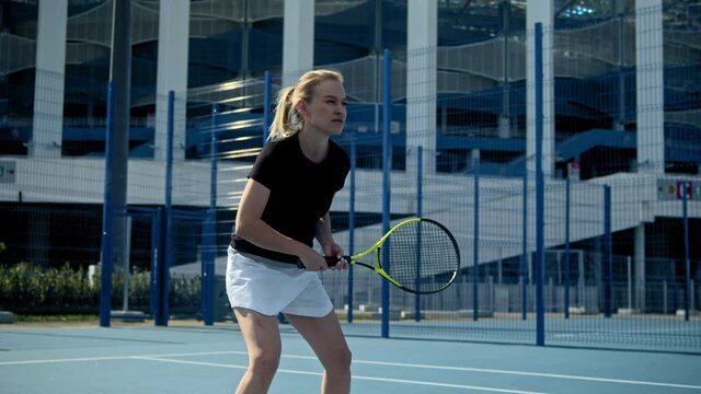 Confident young woman playing tennis outdoor court, professional player, female sport, european sporty girl, cardio workout. Tennis game.