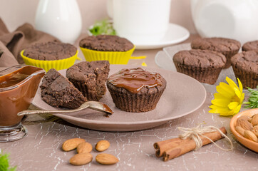 Chocolate muffins on a beige background, side view. Home baked