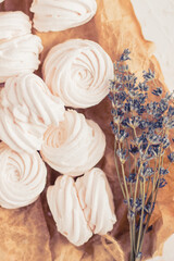 Homemade russian zephyr made of apples, raspberry and blackberry on white concrete background isolated. Free copy space. White marshmallow on the brown beige paper