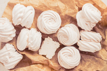 Homemade russian zephyr made of apples, raspberry and blackberry on white concrete background isolated. Free copy space. White marshmallow on the brown beige paper