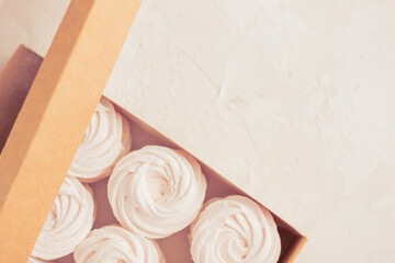 Homemade russian zephyr made of apples, raspberry and blackberry in beige gift box on white concrete background isolated. Free copy space. White marshmallow with the lavander