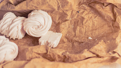 Homemade russian zephyr made of apples, raspberry and blackberry on white concrete background isolated. Free copy space. White marshmallow on the brown beige paper