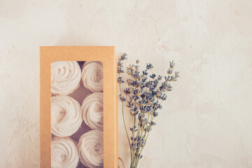 Homemade russian zephyr made of apples, raspberry and blackberry in beige gift box on white concrete background isolated. Free copy space. White marshmallow with the lavander