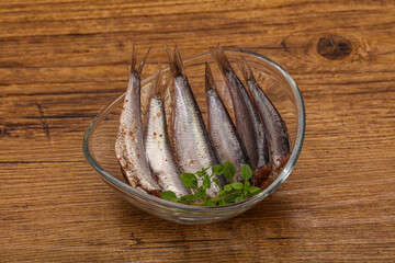 Anchovies in the bowl served basil leaves
