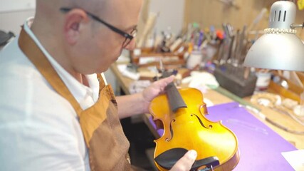 Luthier installing sound post to violin