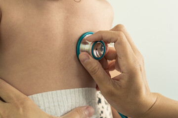 Fototapeta premium Detail of stethoscope checking baby's back at the doctor clinic