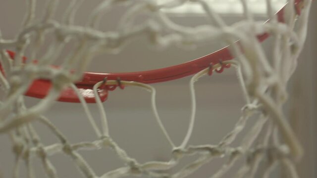 Close Up, Rack Focus of New Basketball Net and Rim in an Empty Gym