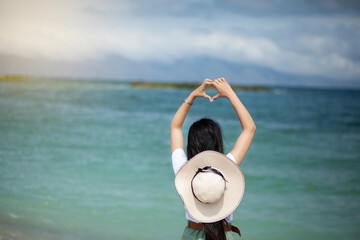 Fototapeta premium woman hand heart sign in sea