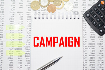 CAMPAIGN on the block on the background of financial reporting, coins, calculator, pens and yellow stickers. Business concept