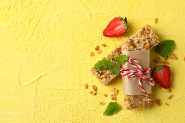 Tasty granola bars on yellow background, top view