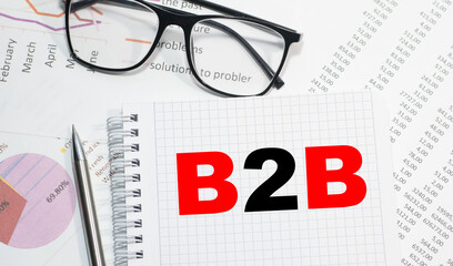 Business concept. Notebook with text b2b sheet of white paper for notes, calculator, glasses, pencil, pen, in the white background