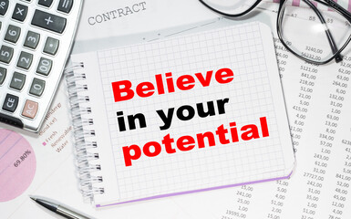 Business concept. Notebook with text Believe in your potential heet of white paper for notes, calculator, glasses, pencil, pen, in the white background