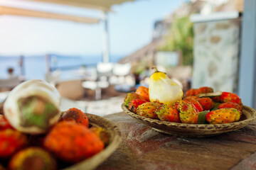 Prickly pear or cactus fruit with white eggplant. Exotic Santorini greek food put on plates in...