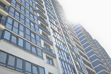 Obraz premium Residential high-rise building with transparent windows to floor. Urban architecture concept