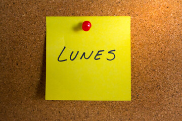 Monday note on a yellow sticky note with push pin. 