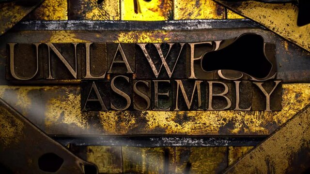 Unlawful Assembly animated mercury blob text formed with real authentic typeset letters on vintage textured silver grunge copper and gold transparent background