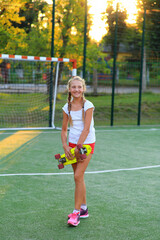 Girl with a skateboard in her hands on the playground
